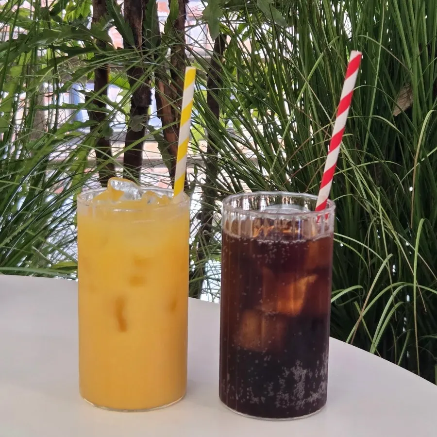 Two glasses of orange juice and zero-sugar cola