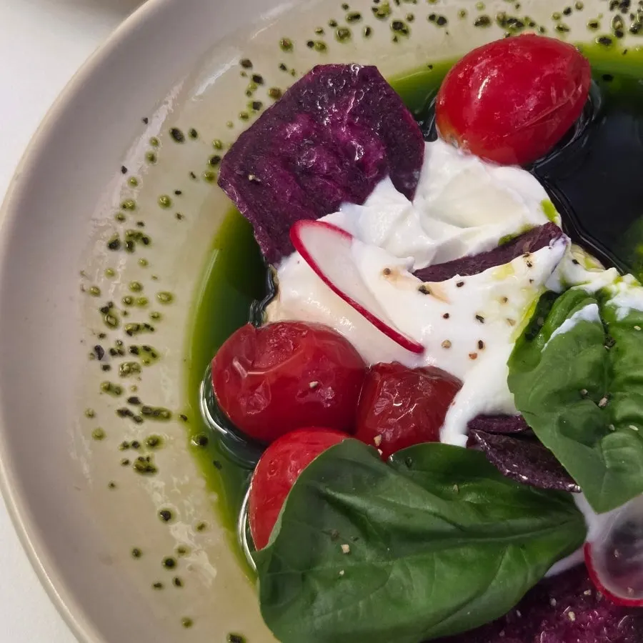Yogurt salad topped with basil and tomato