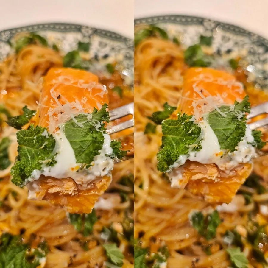 A plate of pasta with tender salmon on top