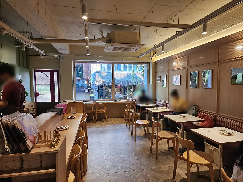 우드톤 인테리어와 식물이 놓인 매장 내부