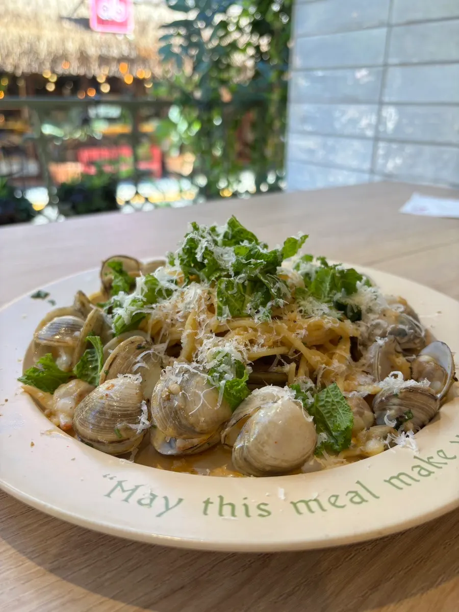 Lifting up a forkful of vongole pasta noodles