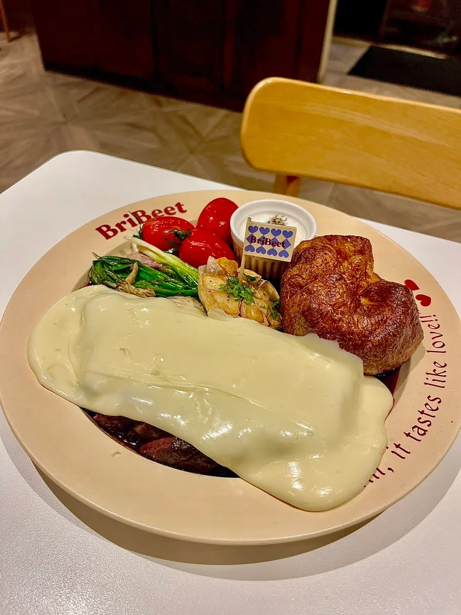 Aligot cheese poured over the steak