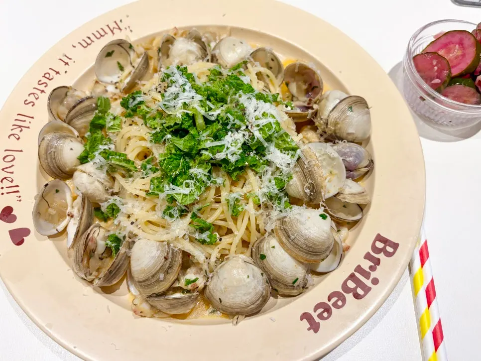 Plate of spicy vongole oil pasta topped with cheese