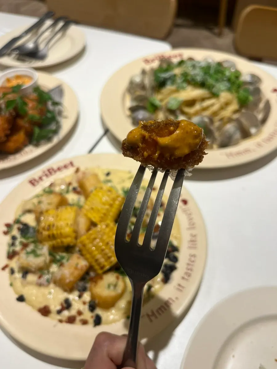 Dipping the fried eggplant into the sauce