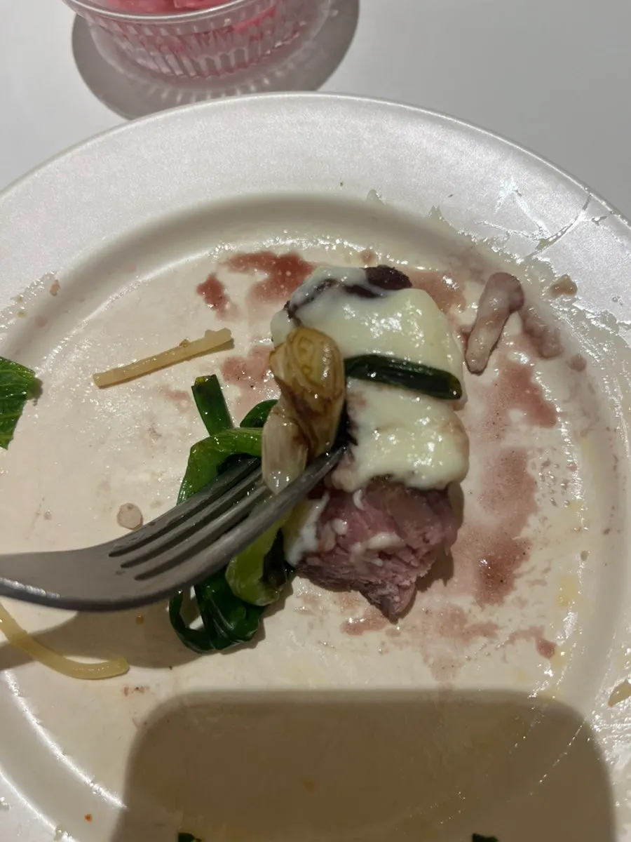 A piece of sous-vide skirt steak lifted with cheese