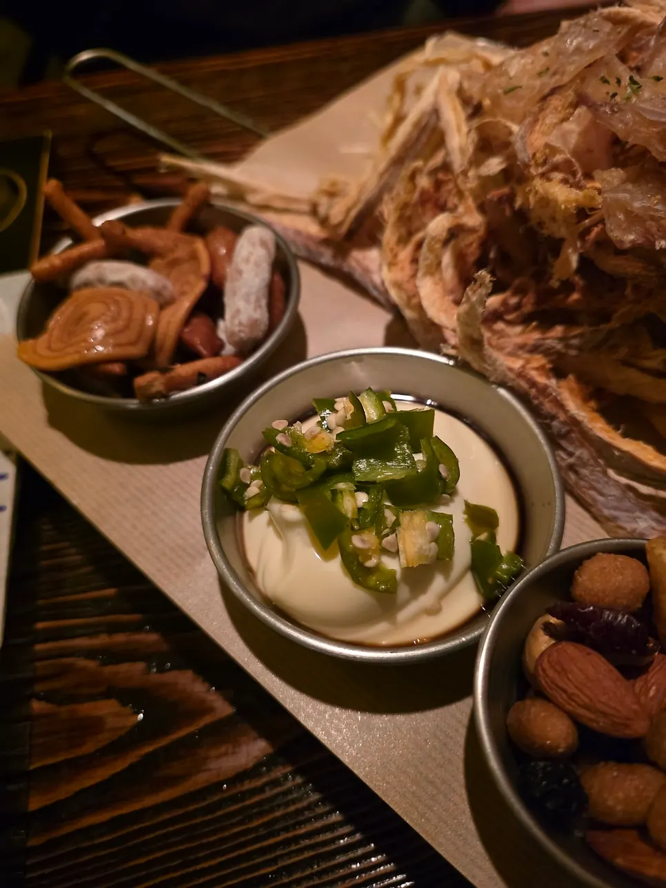 Crackers and nuts served alongside the dried pollack snack