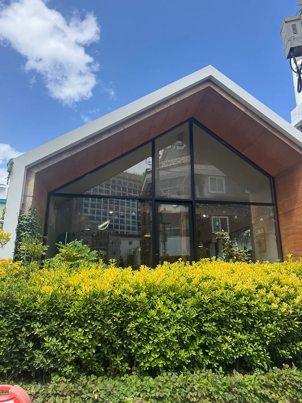 Fachada de Café Buajang con toldo verde