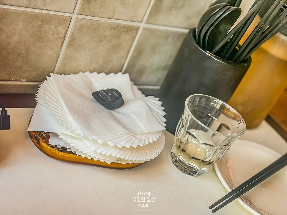 티슈와 수저, 컵이 놓인 기본 테이블 세팅