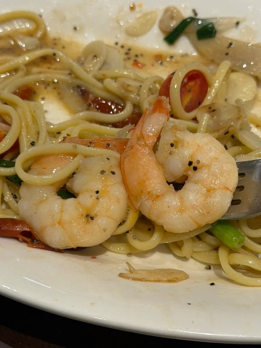 Oil pasta noodles topped with five shrimp