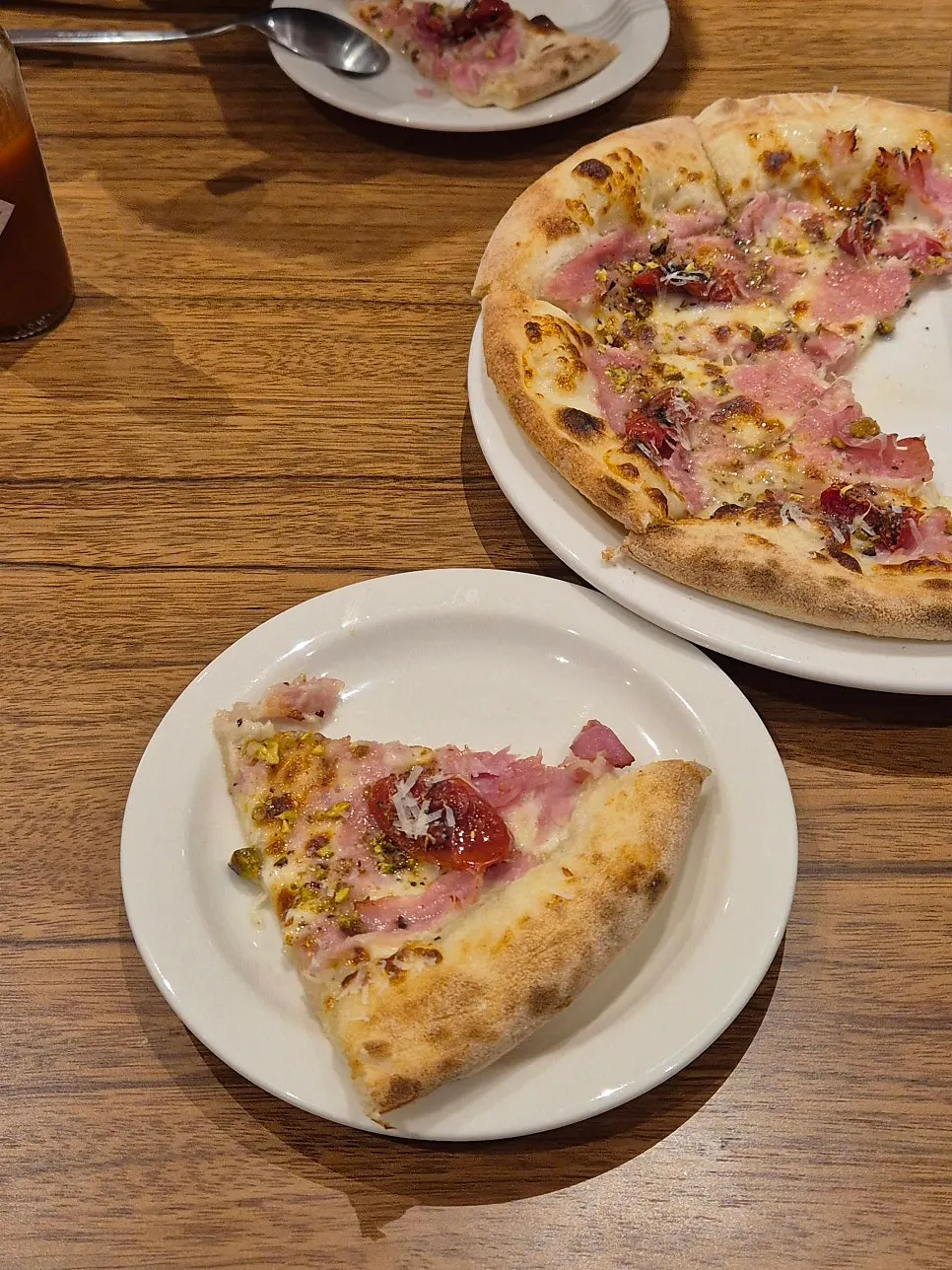A lifted slice showing the jambon pizza's crust cross-section