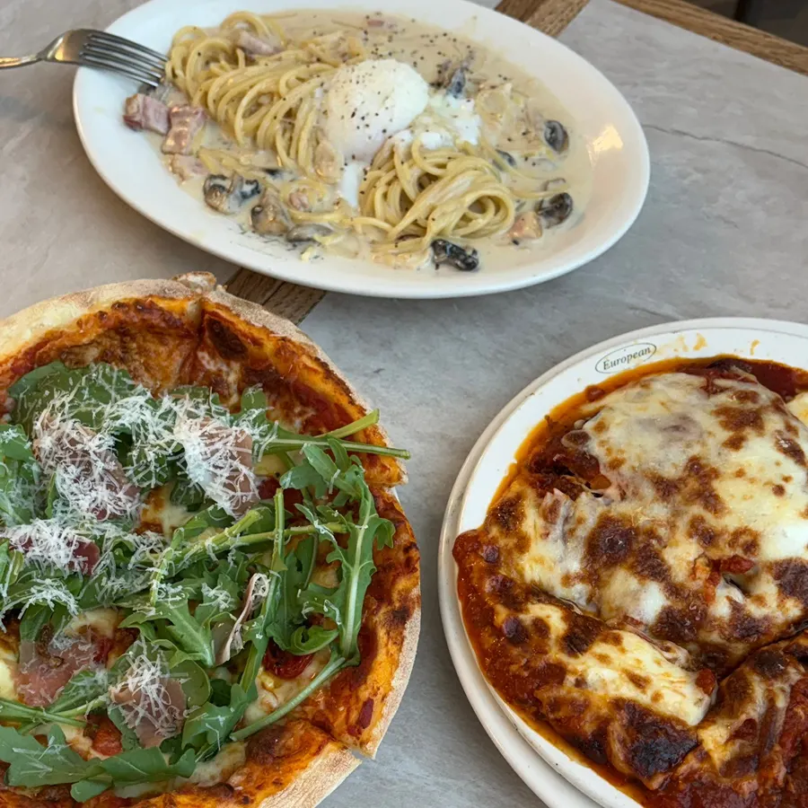 A table set with pizza, pasta and lasagna
