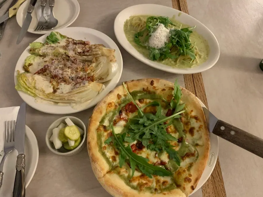 Salad, pasta and pizza arranged on the table