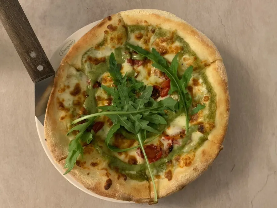 Basil margherita wood-fired pizza topped with roasted tomatoes