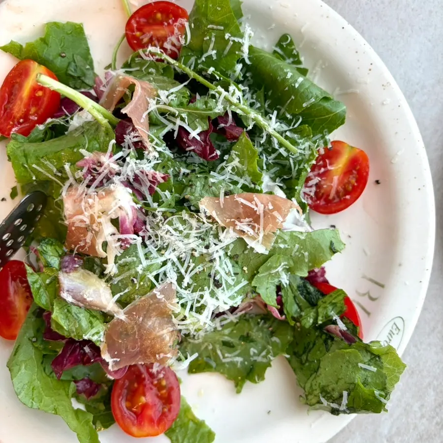 Garden salad topped with grated cheese and cherry tomatoes