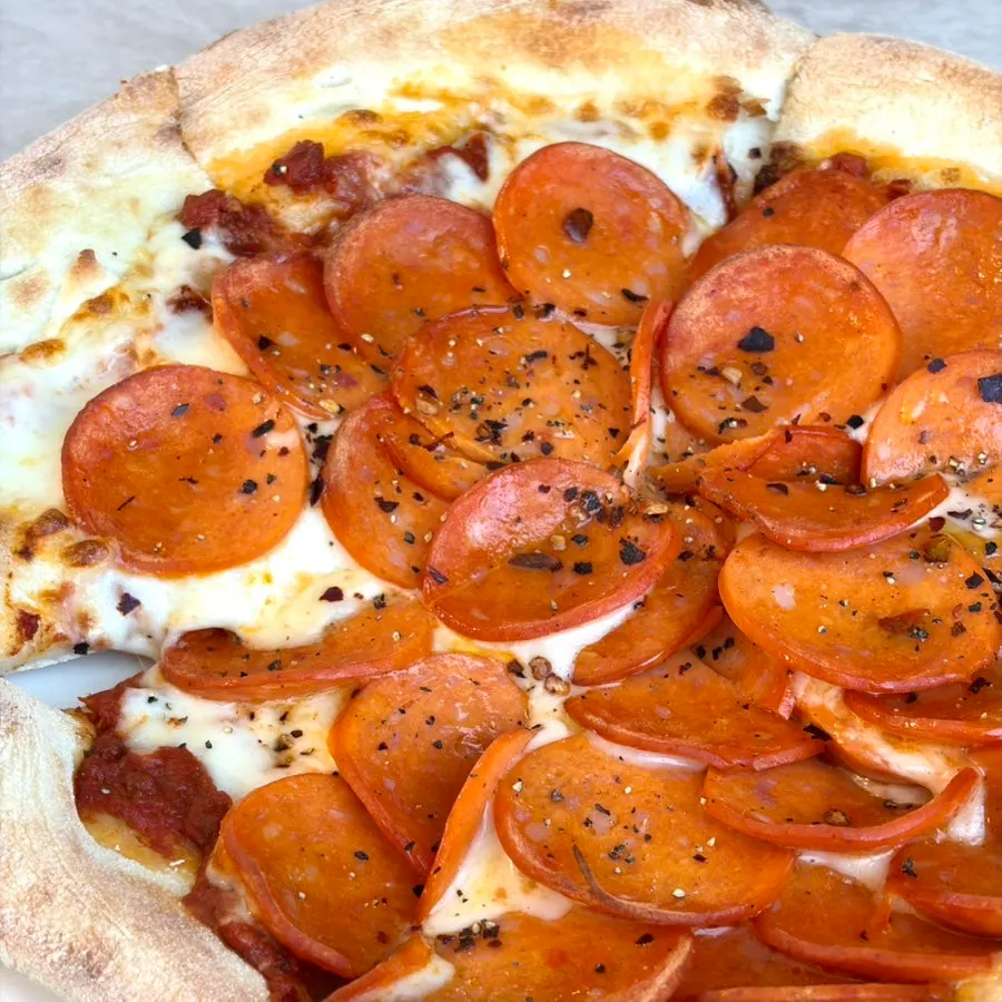 Pizza covered edge to edge with pepperoni