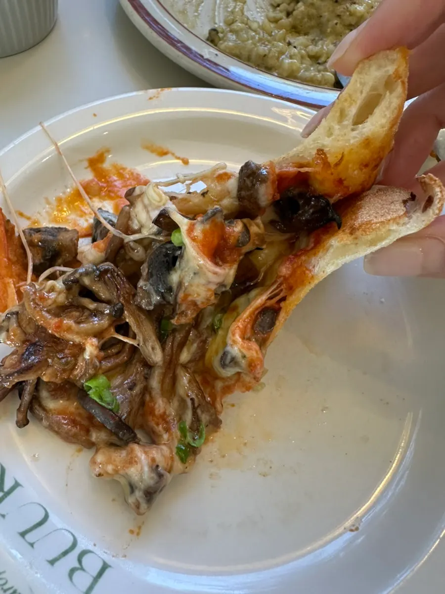 A pizza slice topped with mushrooms and cheese