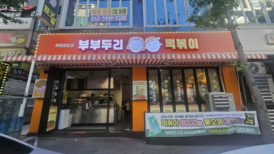 만화 캐릭터가 그려진 오렌지색 매장 간판