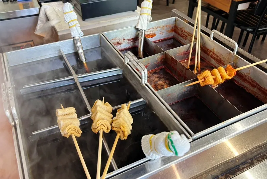 Kitchen counter with tteokbokki and fried snacks at Bubu Duri Tteokbokki