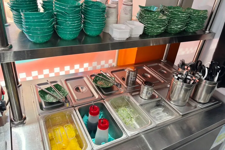 Small plates, pickled radish, and green onion set up at the self-serve bar