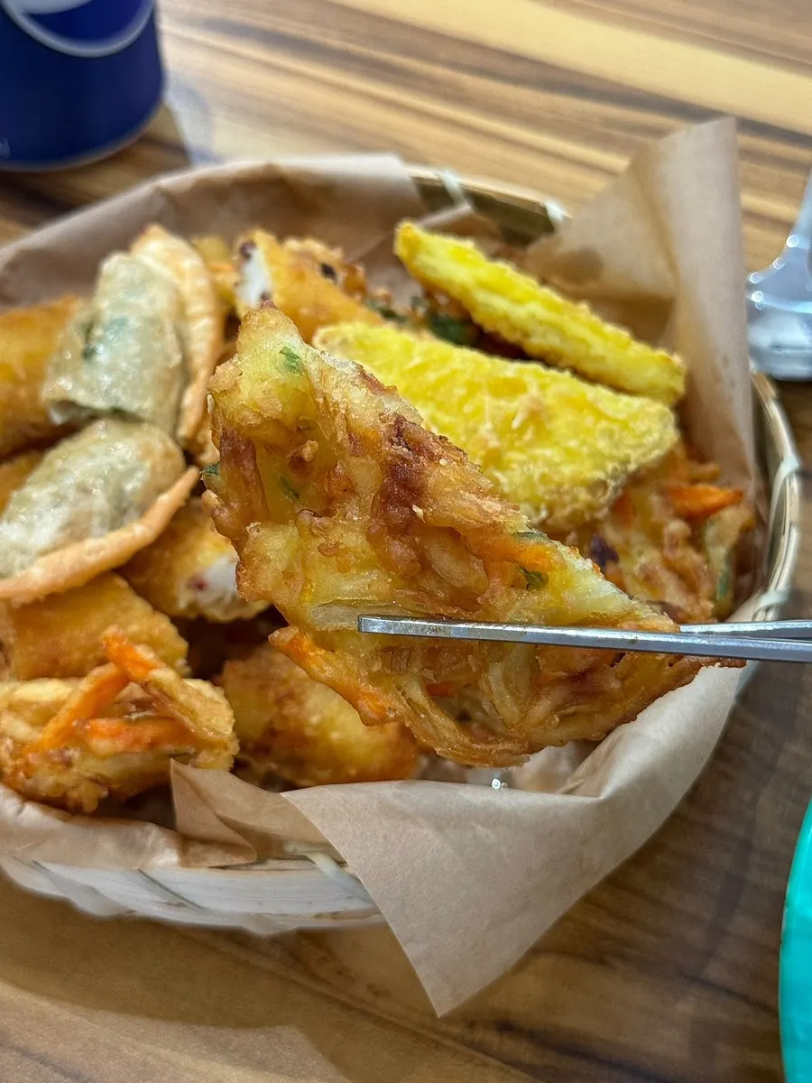 Vegetable fritters dipped in soy sauce