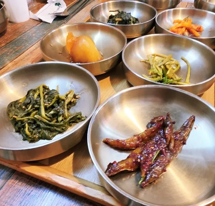 Banchan including pickled chili peppers and japchae