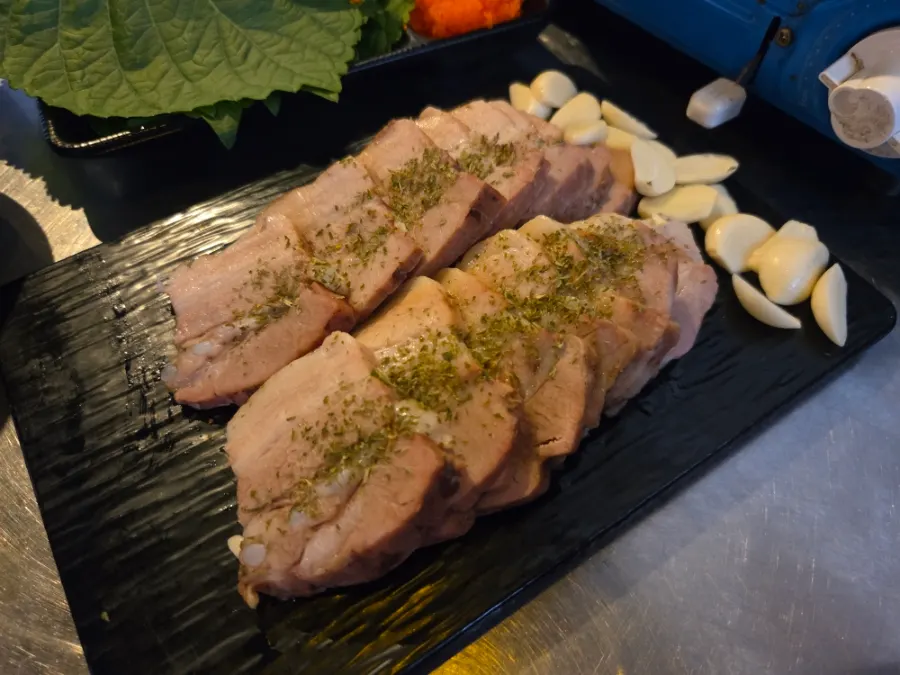 Jjukkumi and pork belly wrapped in a lettuce leaf