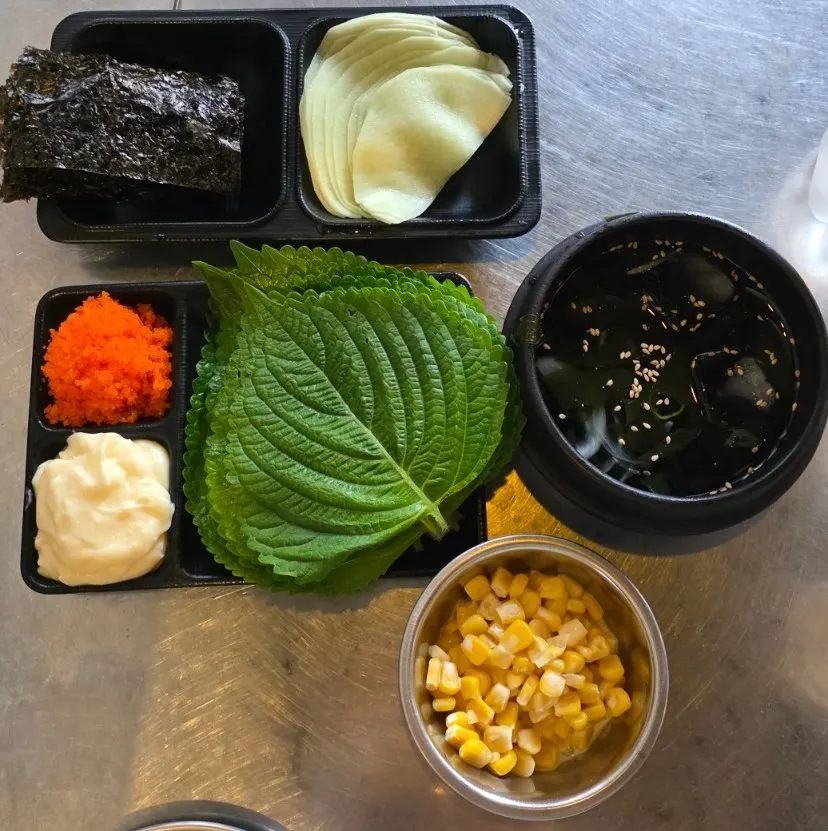 Side dishes including perilla leaf, seaweed, pickled radish, and cold soup