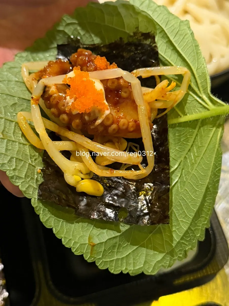 Wrapping jjukkumi in perilla leaf and seaweed