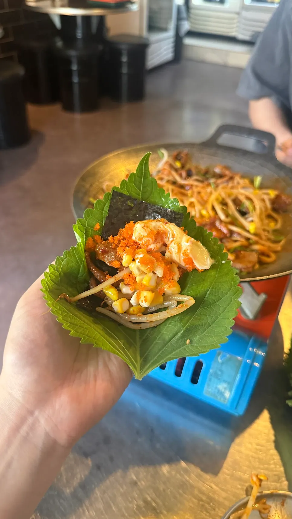 A wrap with jjukkumi and pork belly on perilla leaf
