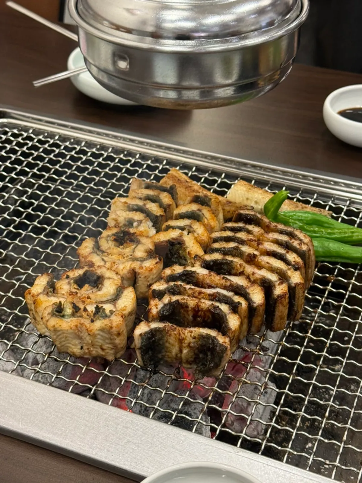 Staff grilling eel over charcoal