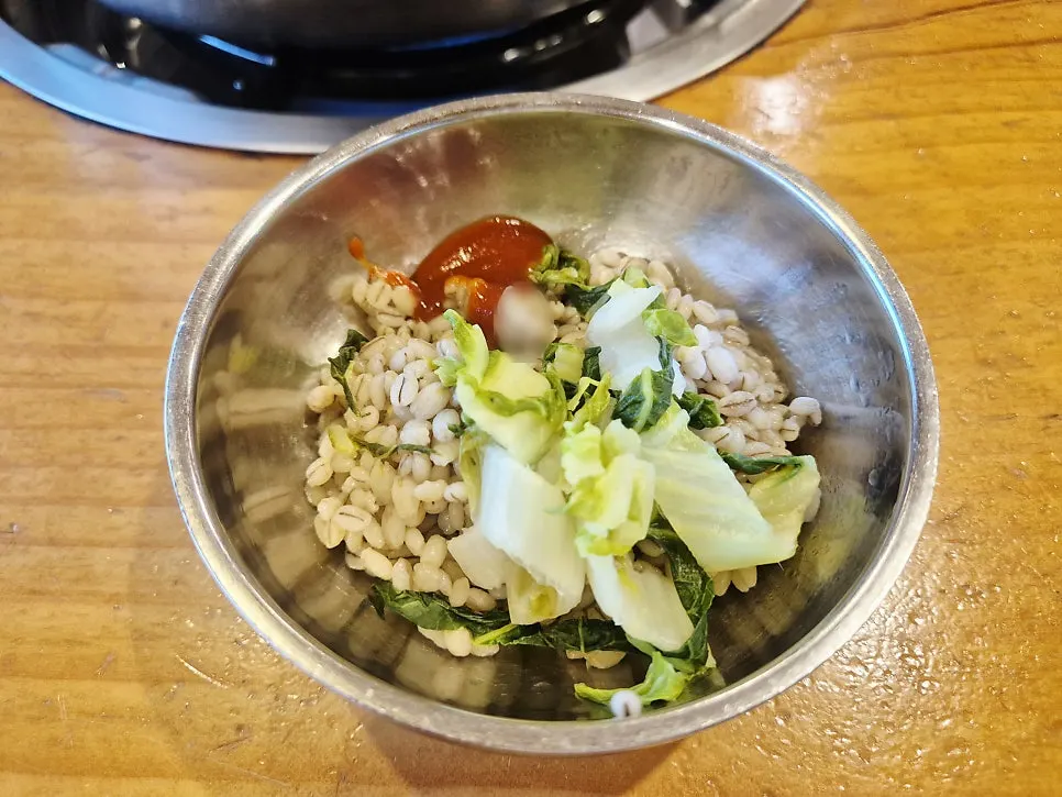 끓는 칼국수 냄비와 옆에 놓인 모래시계
