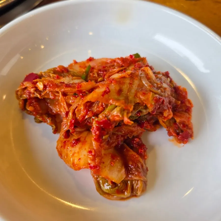 Kimchi served alongside soy milk noodles and dumplings