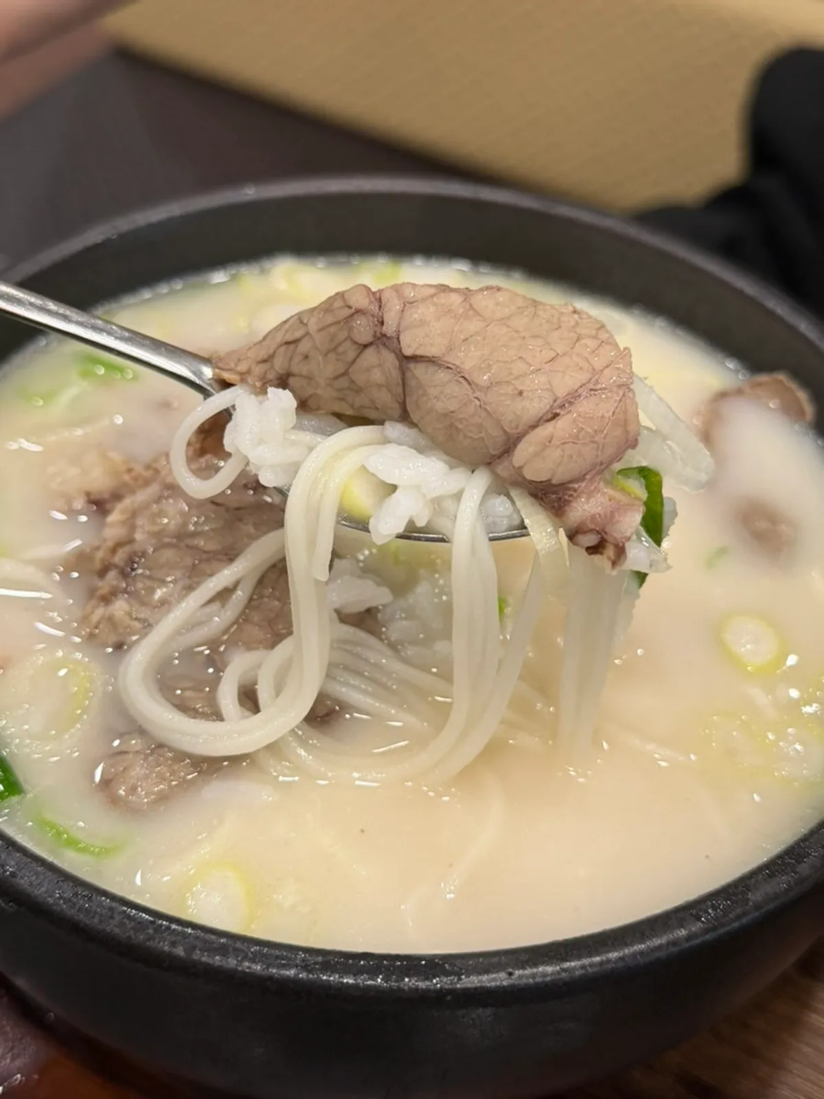A spoonful of meat and noodles lifted from the special seolleongtang