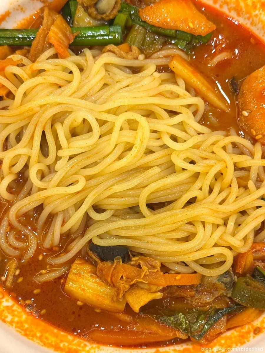 Lifting up jjamppong noodles soaked in broth