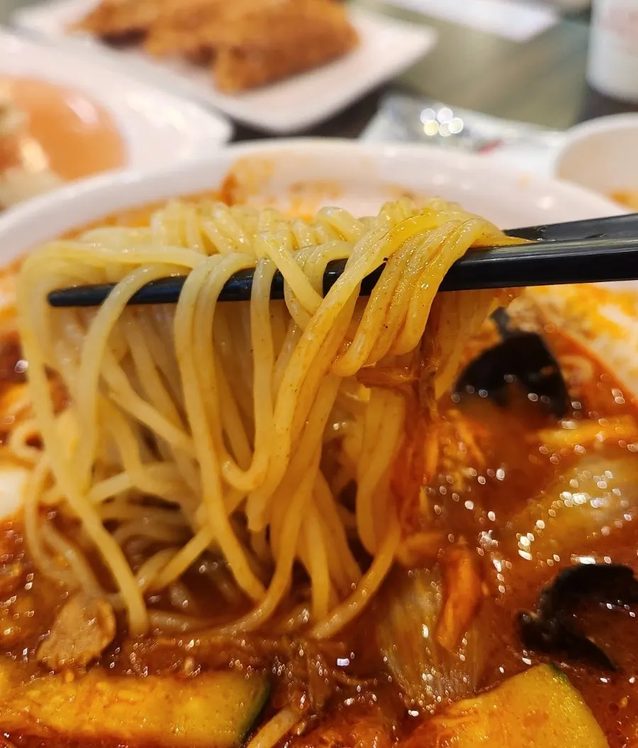 Chopsticks lifting noodles from the seafood jjamppong