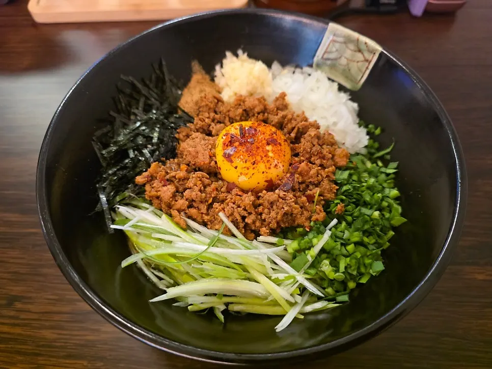 Karaimazesoba topped with egg yolk and toppings