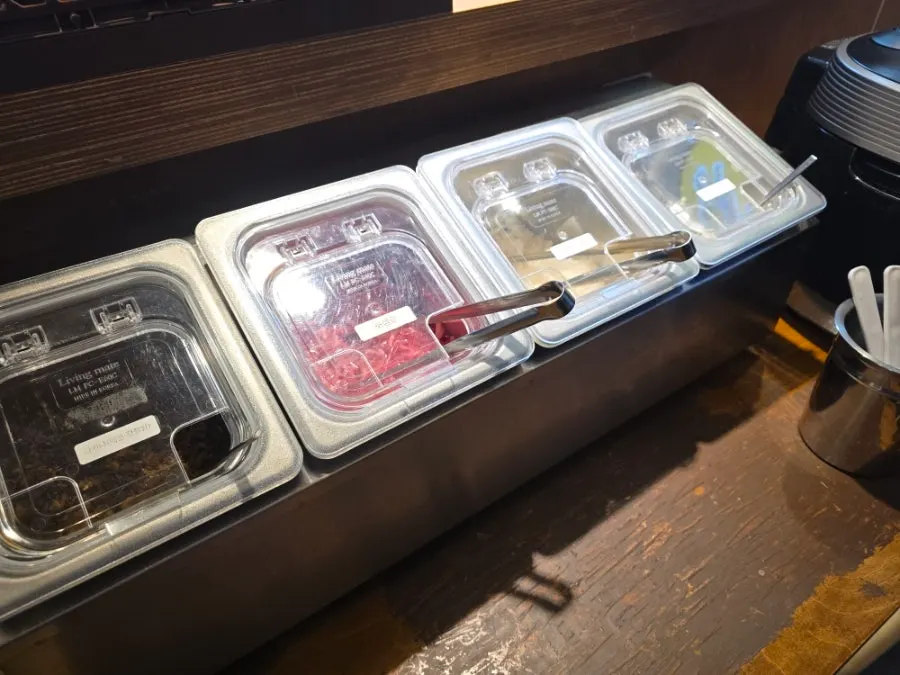 Self-serve side-dish bar beside the rice