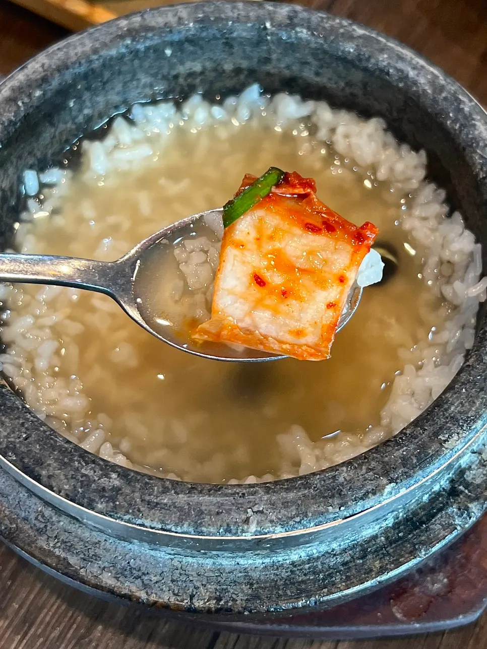 A final spoonful of sungnyung topped with kimchi