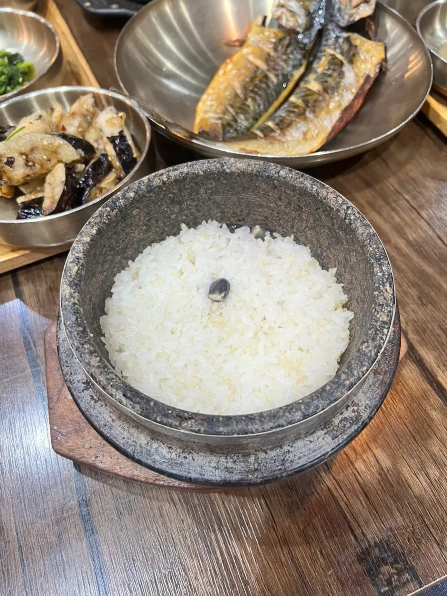 Tteuranchae Bapsang table set with stone-pot rice, cheonggukjang, and grilled mackerel