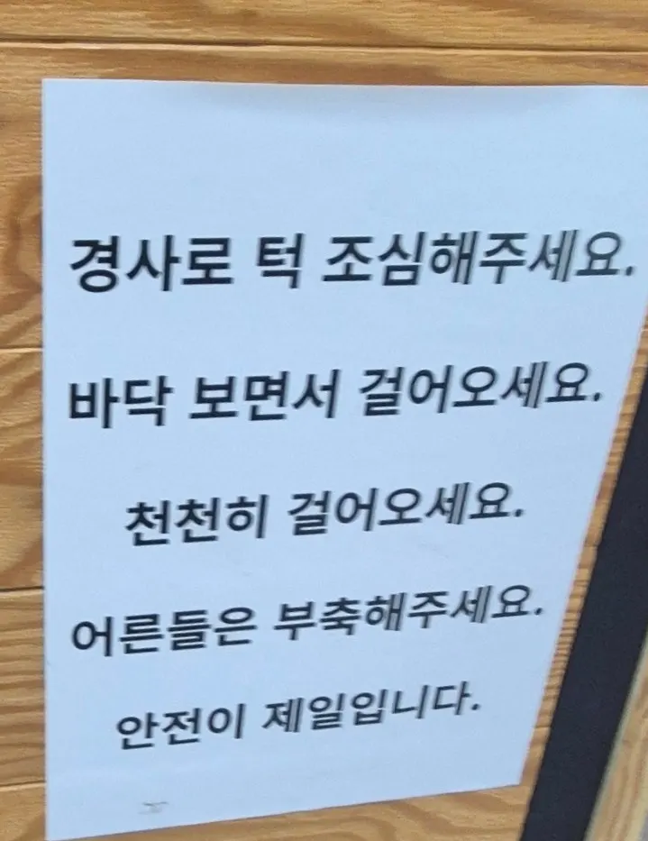 Warning sign about a step on the ramp between waiting area and dining room