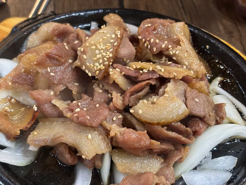 양파와 함께 담긴 숯불돼지구이
