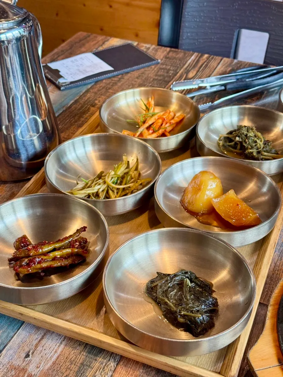 Close-up of doraji-muchim and braised potatoes among the banchan