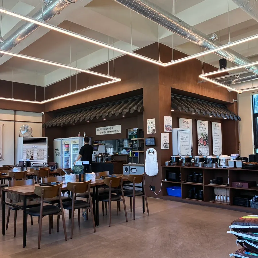 High-ceilinged dining hall with floor-to-ceiling windows and tiled-roof interior