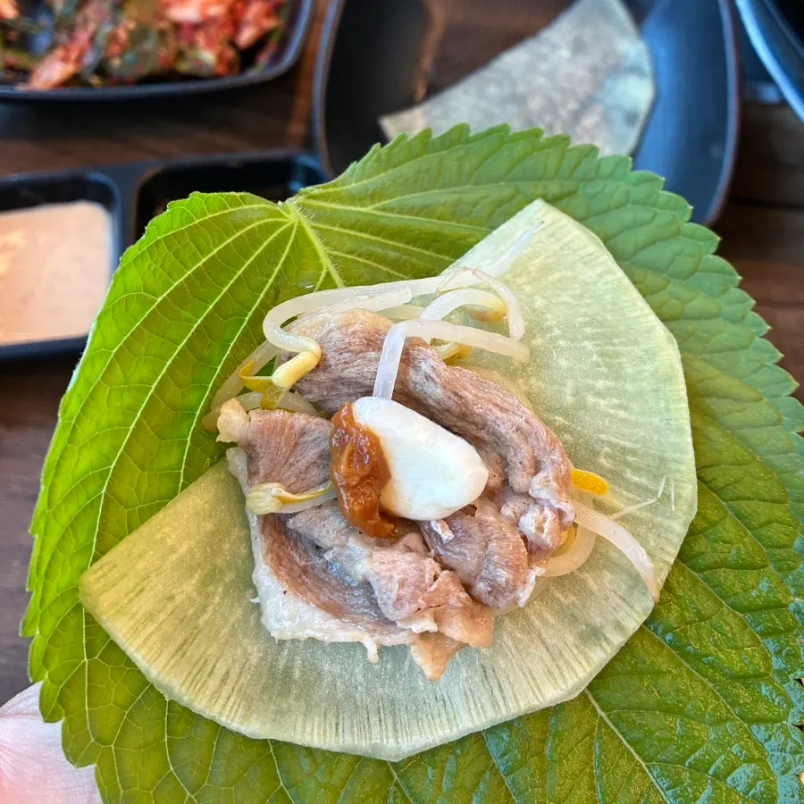 Duck wrap with perilla leaf, pickled radish, and garlic