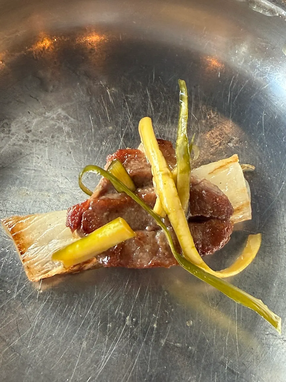백김치와 절임 반찬을 곁들인 고기 한 점