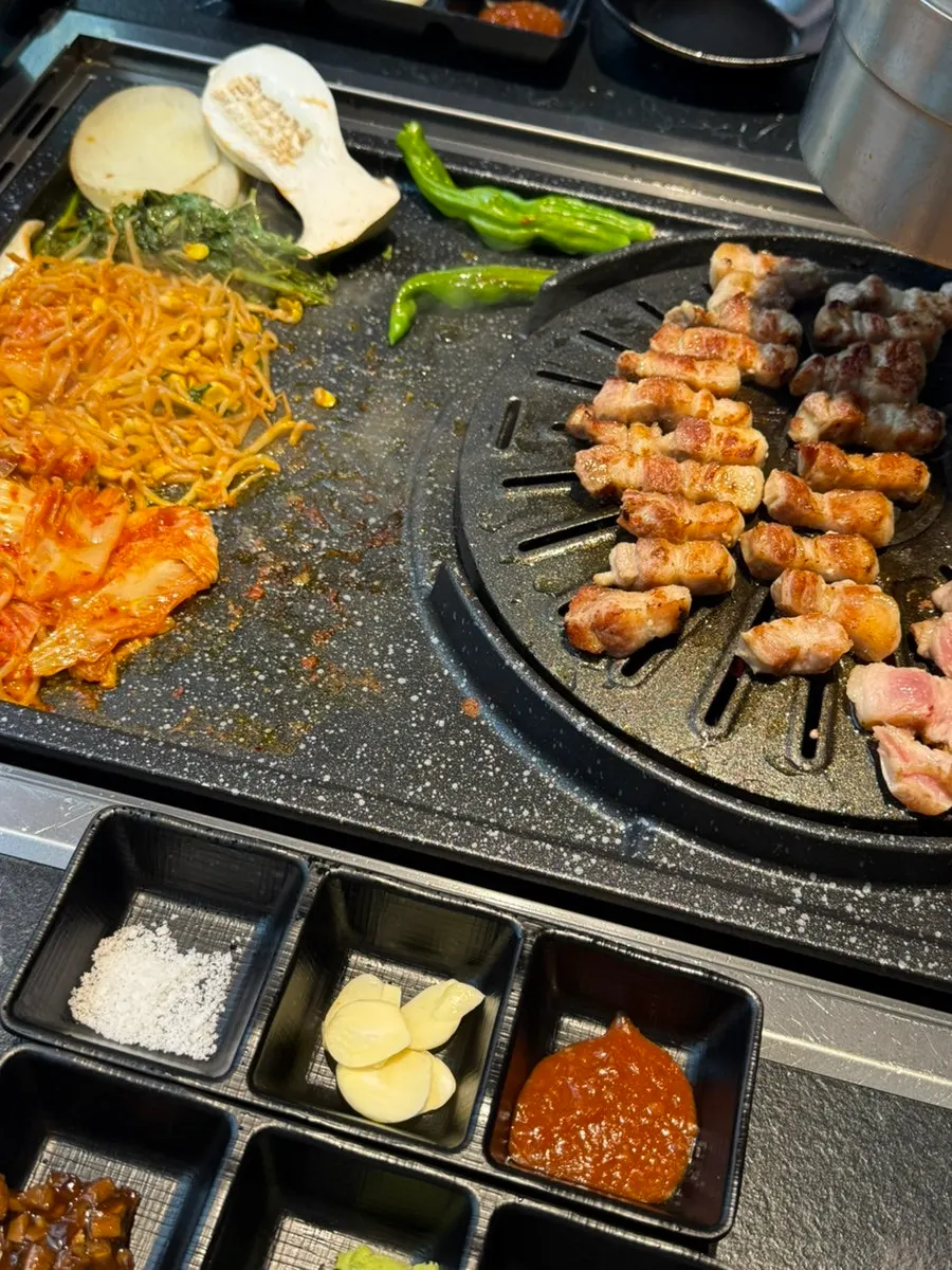 Foto del personal colocando el samgyeopsal en la plancha
