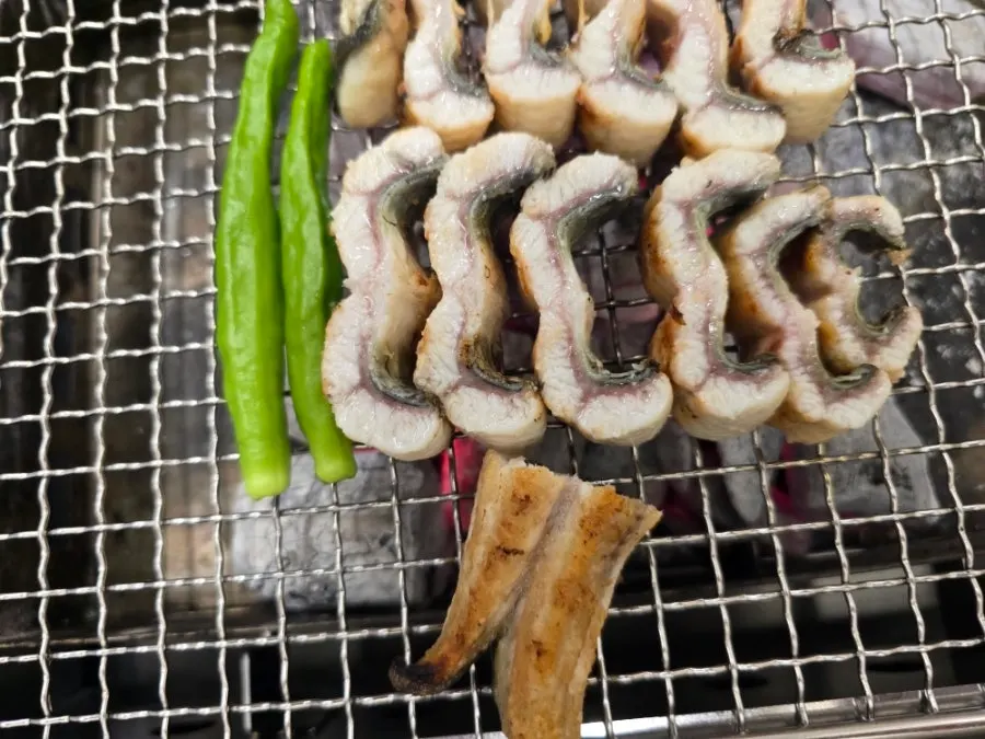 A full table of grilled eel, eel soup, and bibim guksu