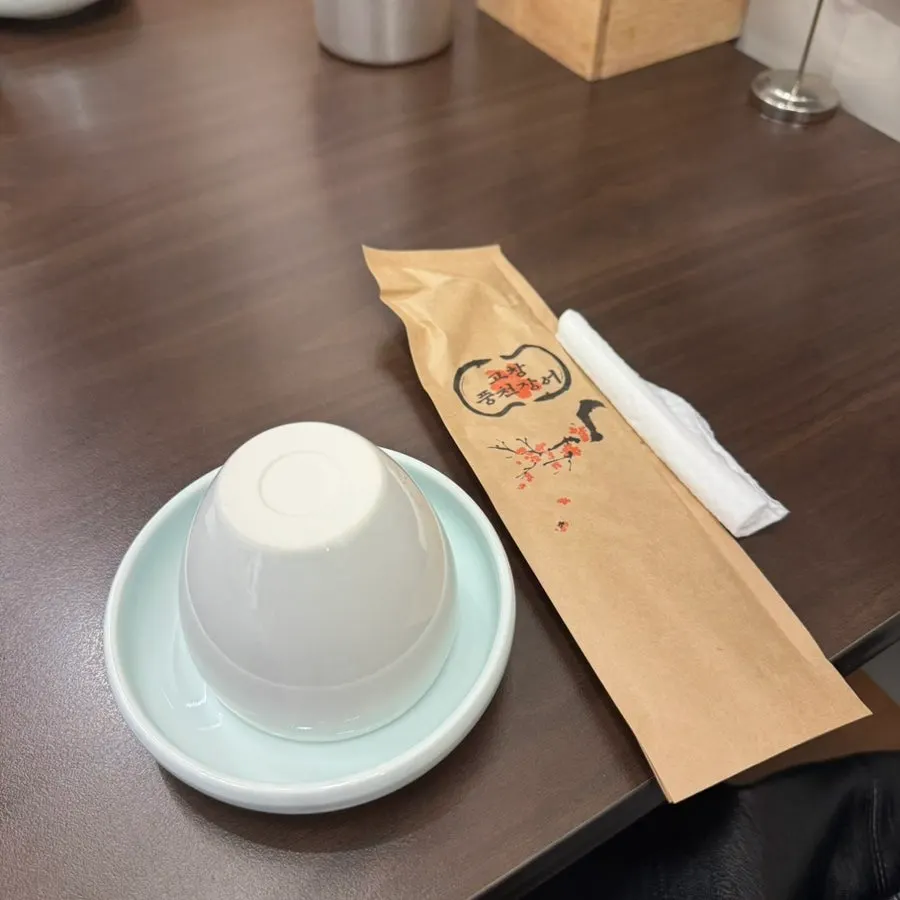 컵과 앞접시, 수저가 놓인 테이블 세팅