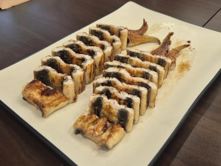 Soy-glazed eel grilling over charcoal