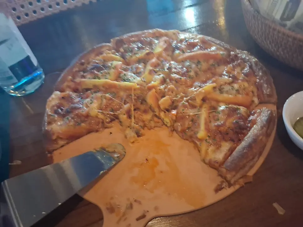 A stretchy cheese-pulled slice of pizza with a highball